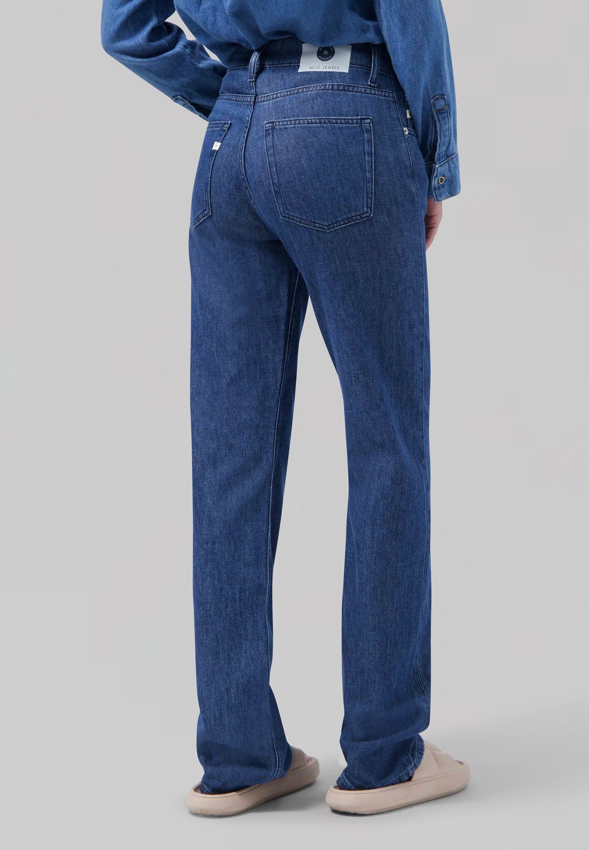 Rear view of sustainable blue denim jeans by MUD Jeans, showcasing a classic, relaxed fit with a high-rise waist.