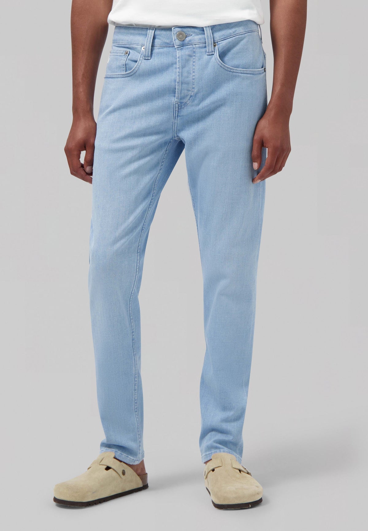 Sustainable MUD Jeans made from organic cotton, in classic blue, paired with a white shirt, showcasing ethical fashion.