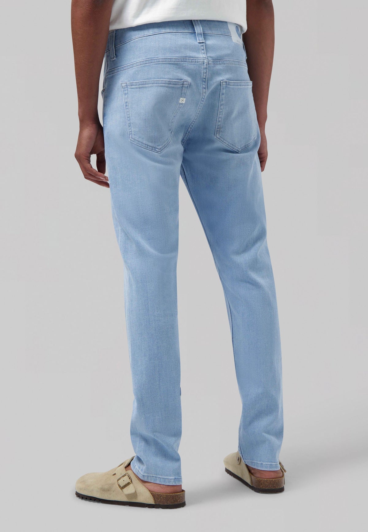 Sustainable MUD Jeans in blue denim, classic straight fit, eco-friendly and made from organic cotton, paired with white shirt.