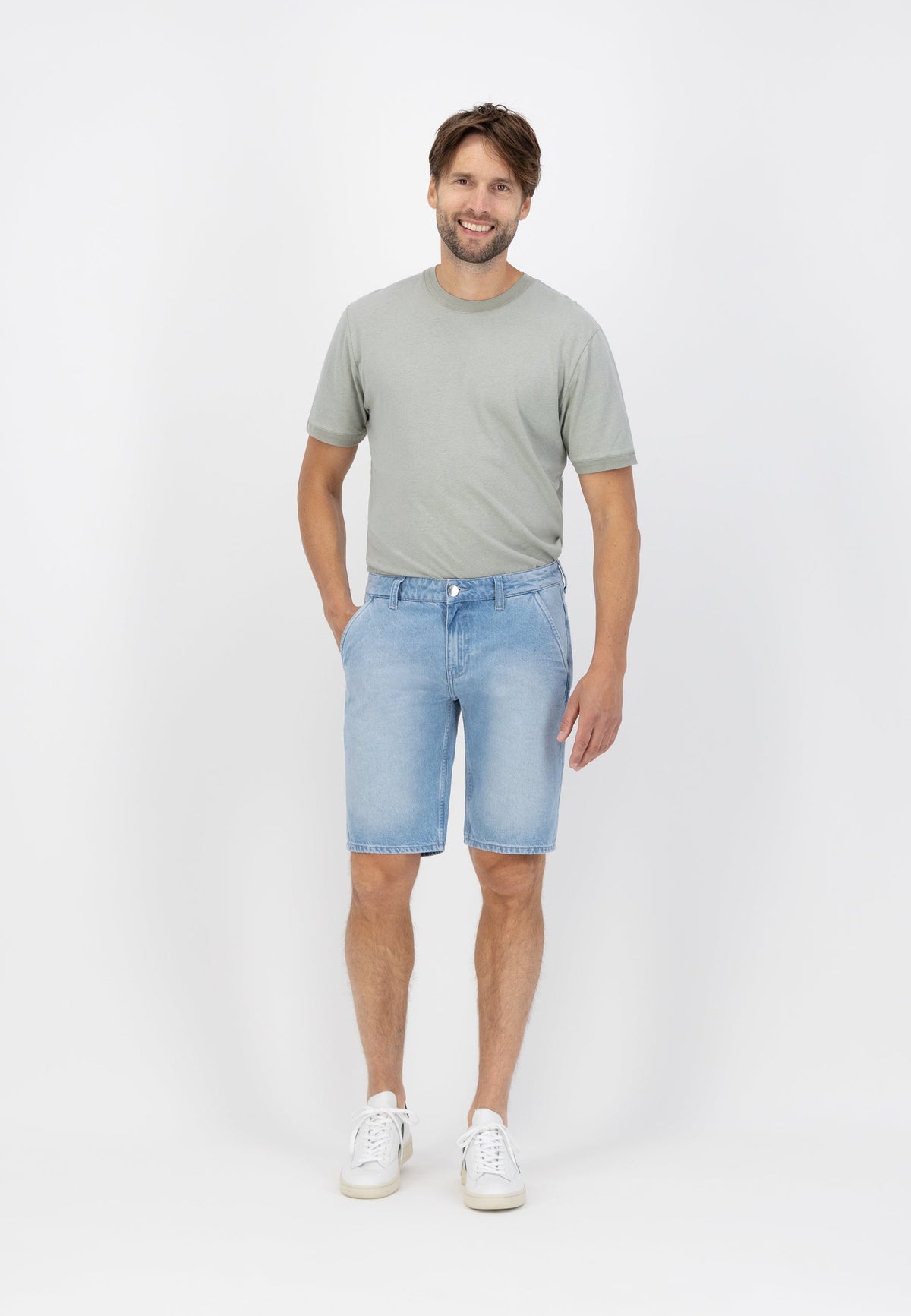 Sustainable MUD Jeans in light blue denim, crafted ethically with organic materials, paired with a sleek black sweater.
