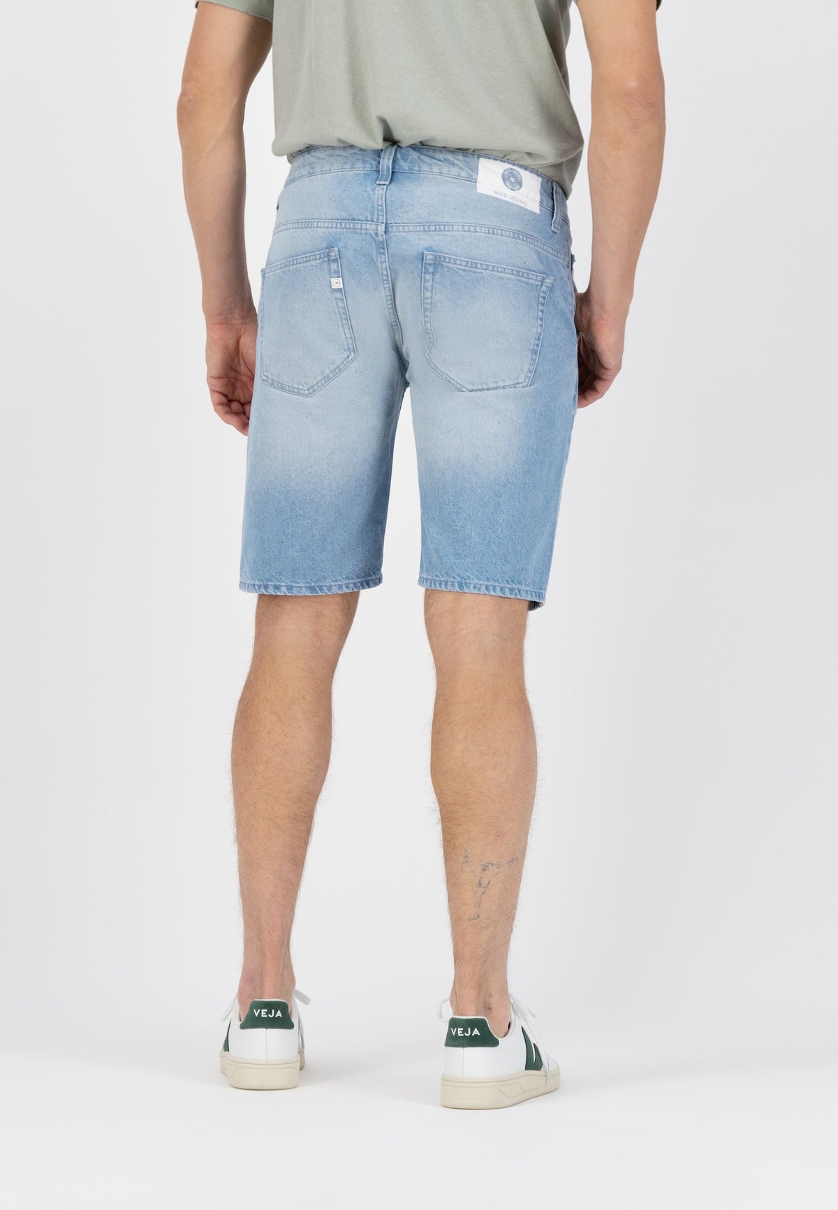 Sustainable MUD Jeans in light blue denim, showcasing ethical fashion with organic cotton, worn with a black sweater.