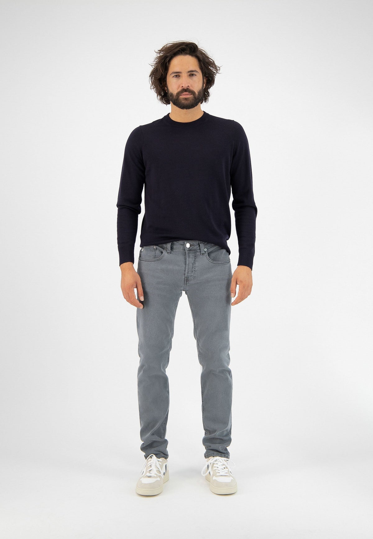 Sustainable MUD Jeans crafted from organic cotton, featuring dark blue denim in a slim fit, paired with a black t-shirt.