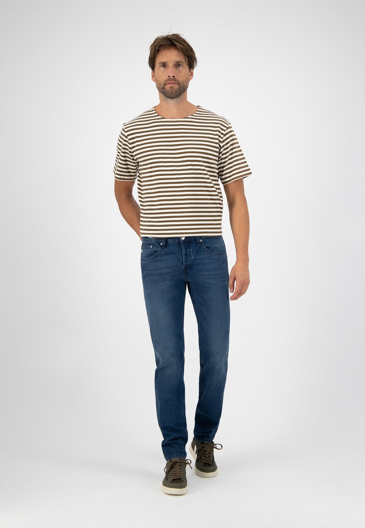 Sustainable MUD Jeans made from eco-friendly denim, featuring dark blue wash, paired with a simple white t-shirt.