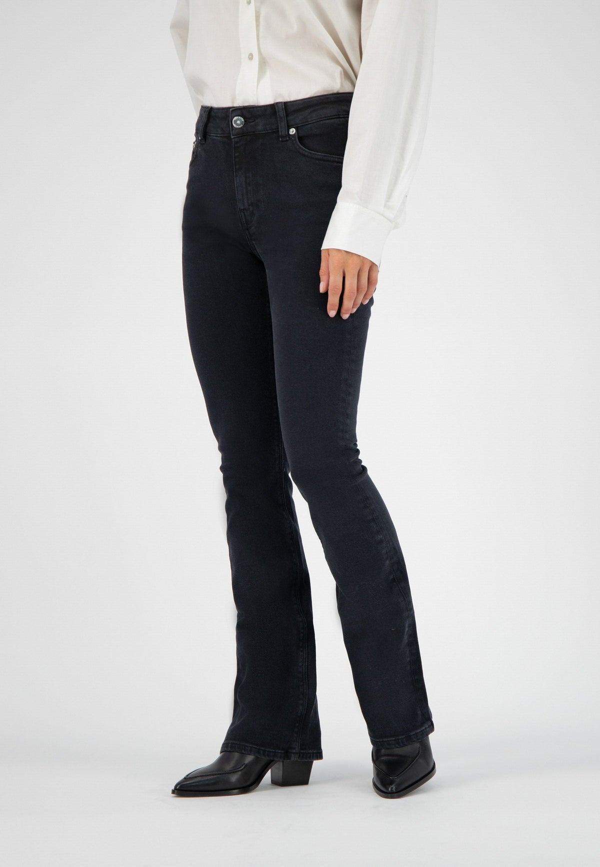 Black flared denim jeans paired with a classic white button-up shirt and black leather ankle boots.