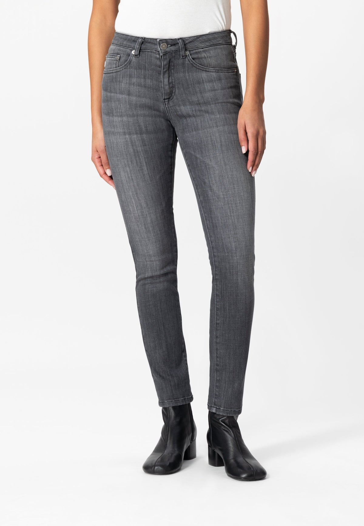 Slim-fit gray jeans made from sustainable fabric, paired with a white top and black ankle boots for a modern look.