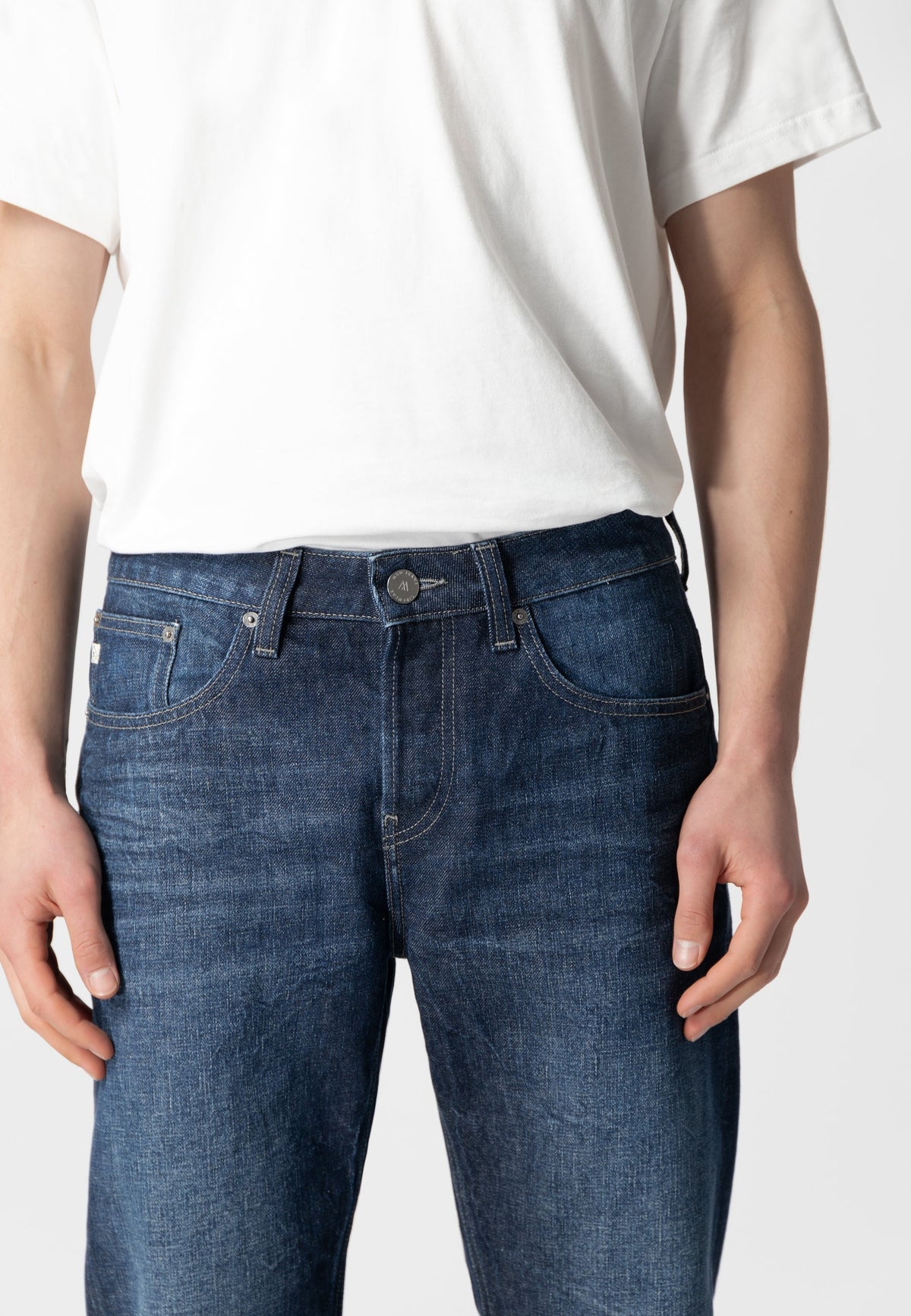 Sustainable MUD Jeans in dark blue organic denim, showcasing ethical fashion with a minimalist design and strong stitching.
