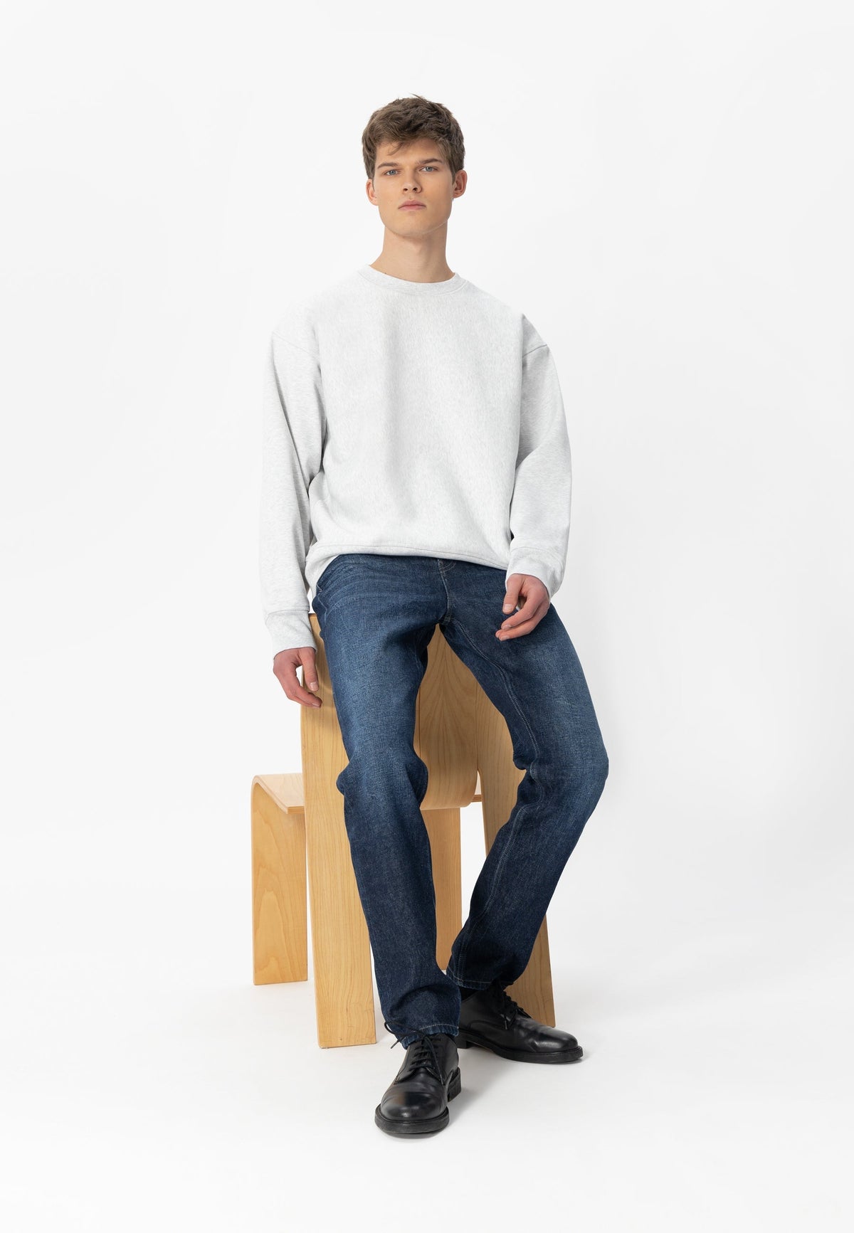 Sustainable MUD Jeans in classic blue denim, featuring eco-friendly materials and ethical production, shown with casual sneakers.