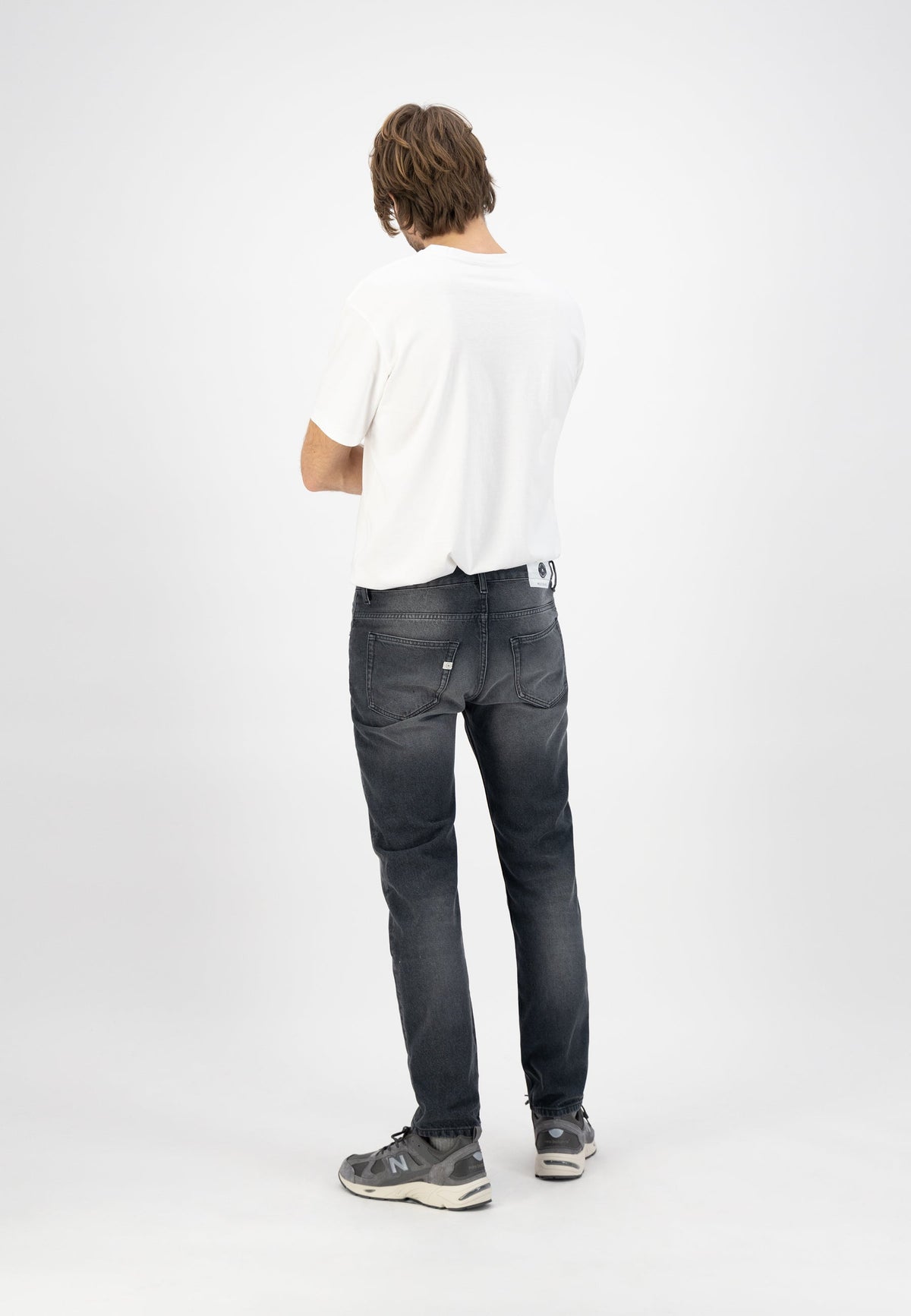 Sustainable MUD Jeans in dark wash denim, styled with a gray sweater, embodying ethical fashion and eco-friendly design.