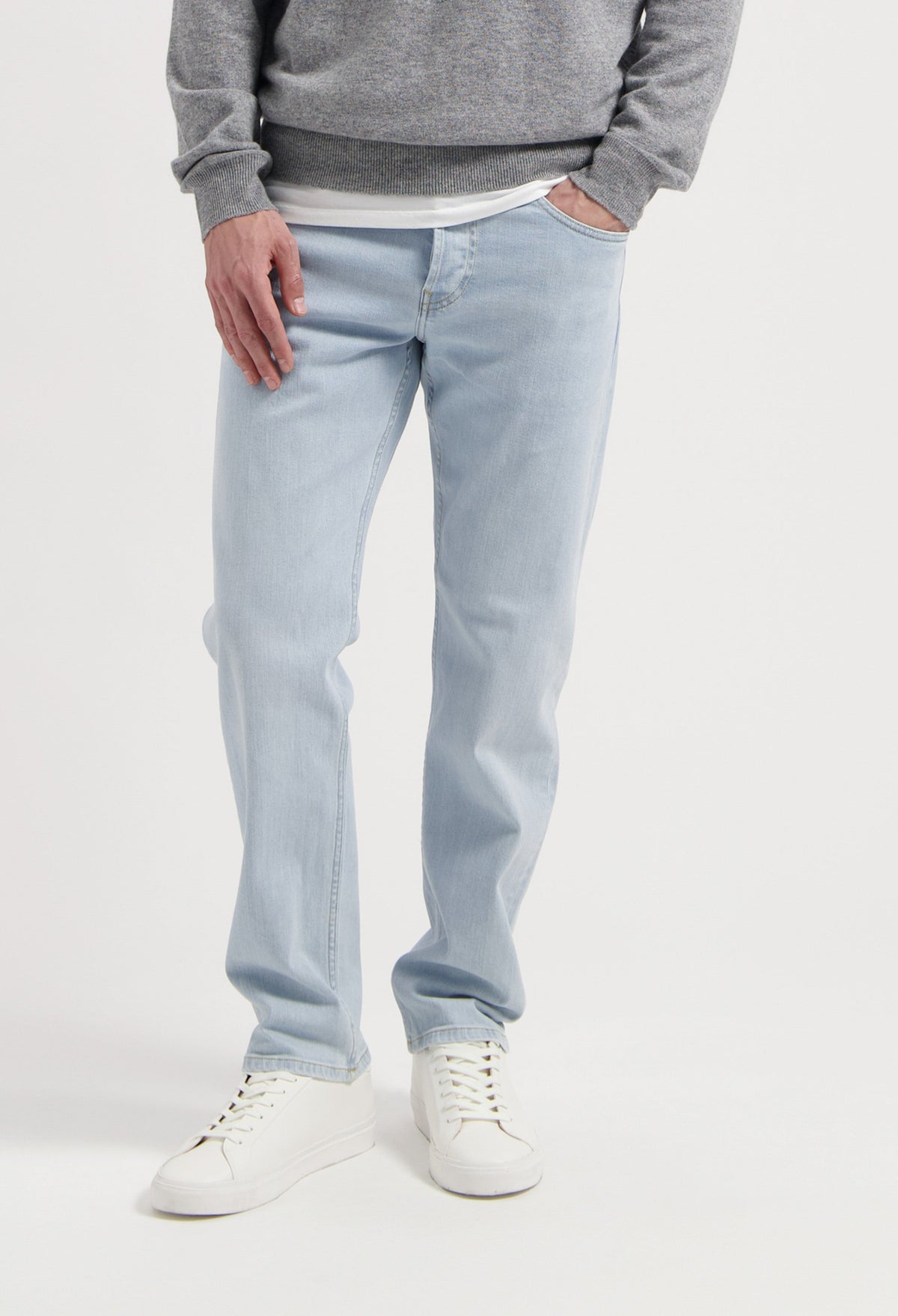 Sustainable MUD Jeans in dark gray denim with a modern fit, showcasing ethical fashion paired with casual sneakers.