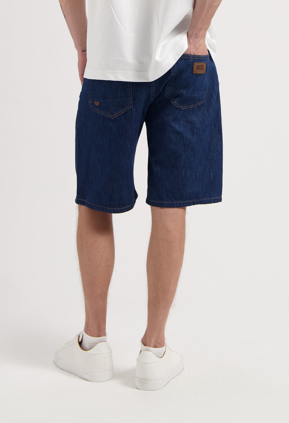 Sustainable MUD Jeans in light blue organic cotton, classic fit, paired with a simple white t-shirt for ethical fashion.