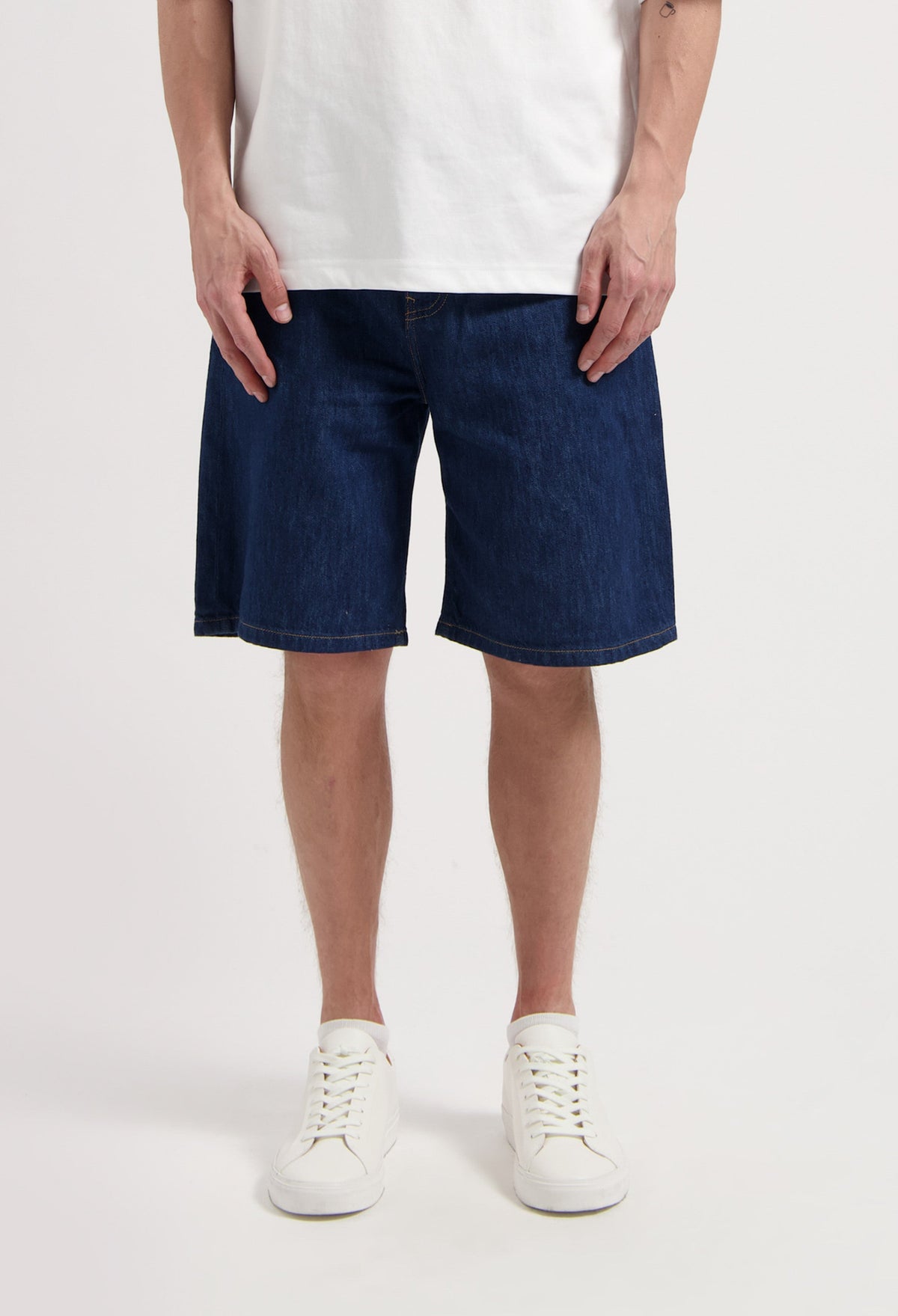 Sustainable MUD Jeans made from organic cotton, featuring light blue denim in a straight fit, paired with casual sneakers.