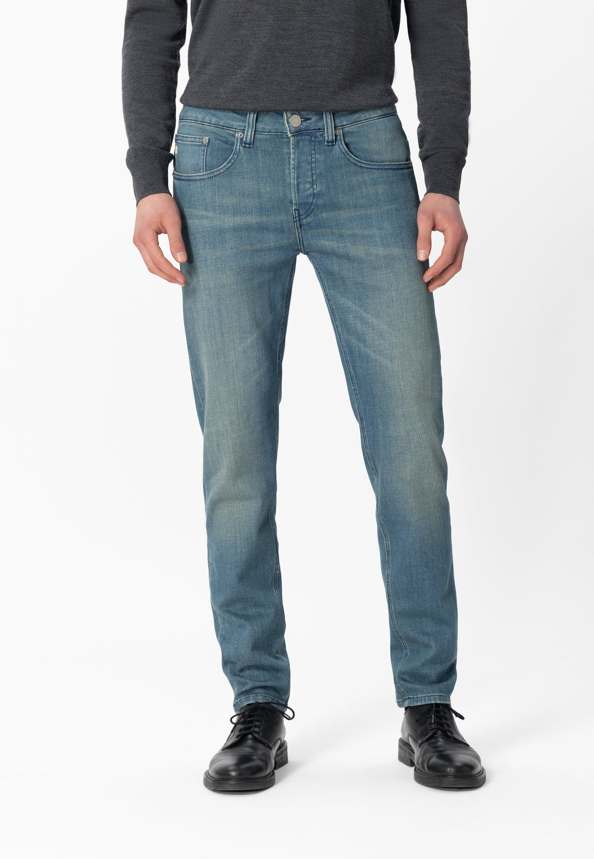 Sustainable MUD Jeans crafted from organic cotton, featuring classic blue denim, paired with a white shirt.