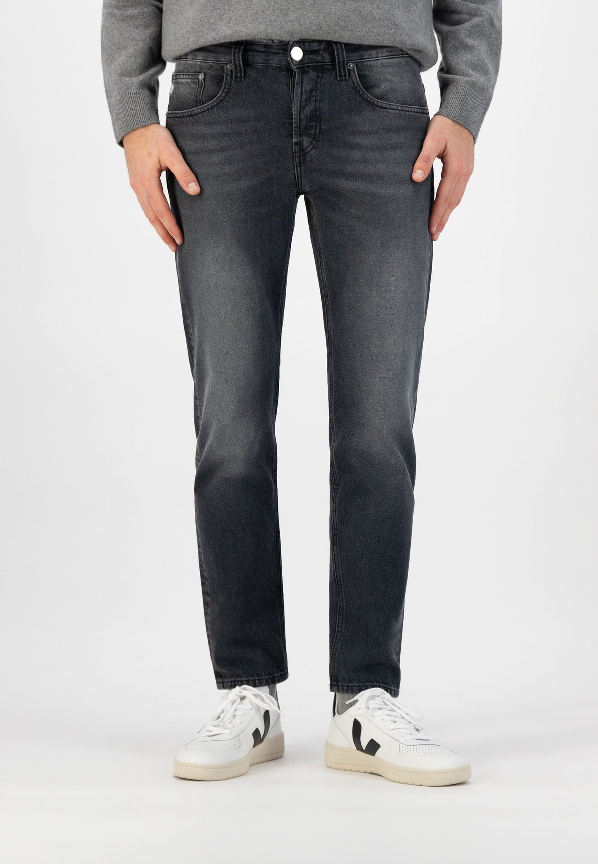 Sustainable MUD Jeans green denim shorts, crafted ethically with organic cotton, styled with a white T-shirt and sneakers.