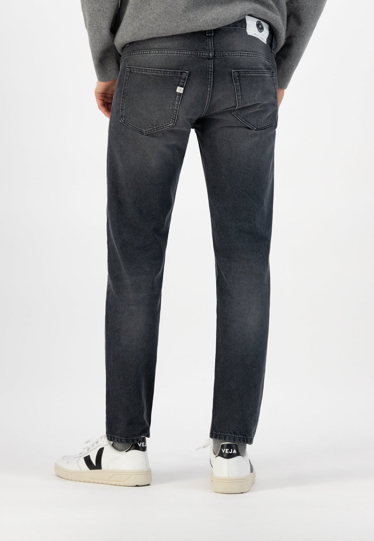 Sustainable MUD Jeans olive green denim shorts, crafted ethically, paired with a white T-shirt and sneakers.