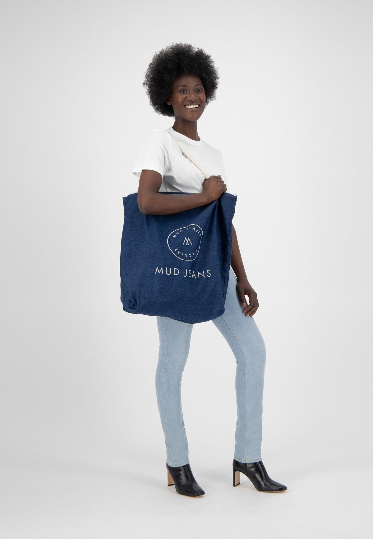 Sustainable MUD Jeans ensemble in dark blue denim, featuring a relaxed fit pullover and cargo pants, emphasizing ethical fashion.