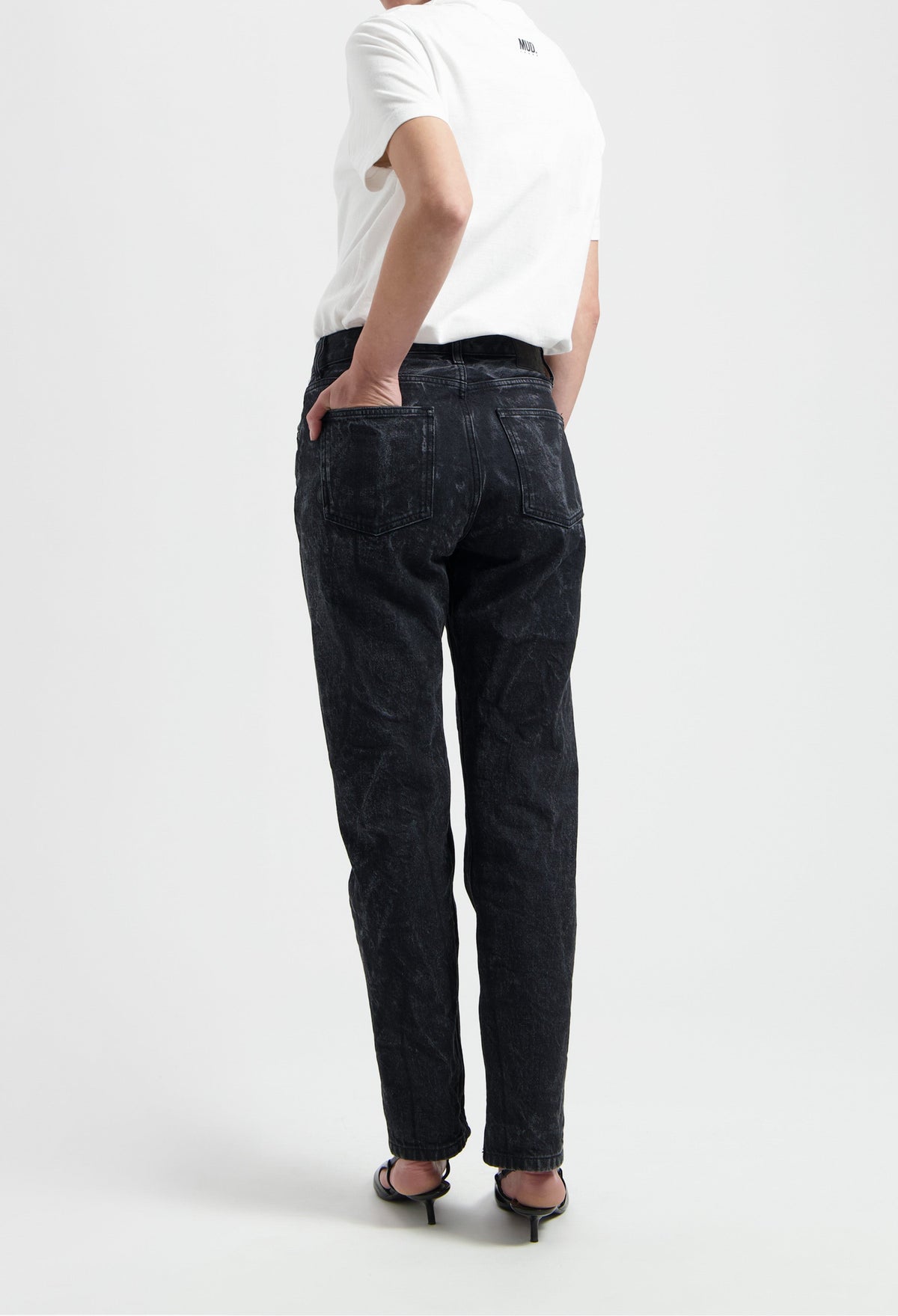 High-waisted black denim jeans with a casual fit, styled with a simple white T-shirt and black strappy sandals.