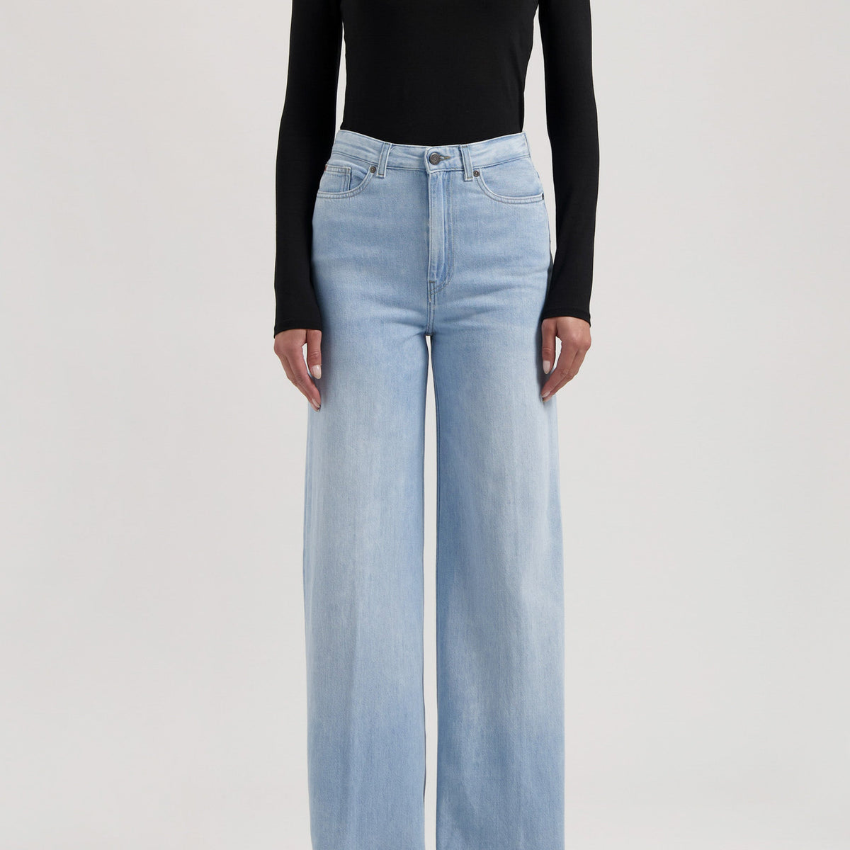 Wide-leg light blue jeans paired with a sleek black long-sleeve top, showcasing modern casual fashion.