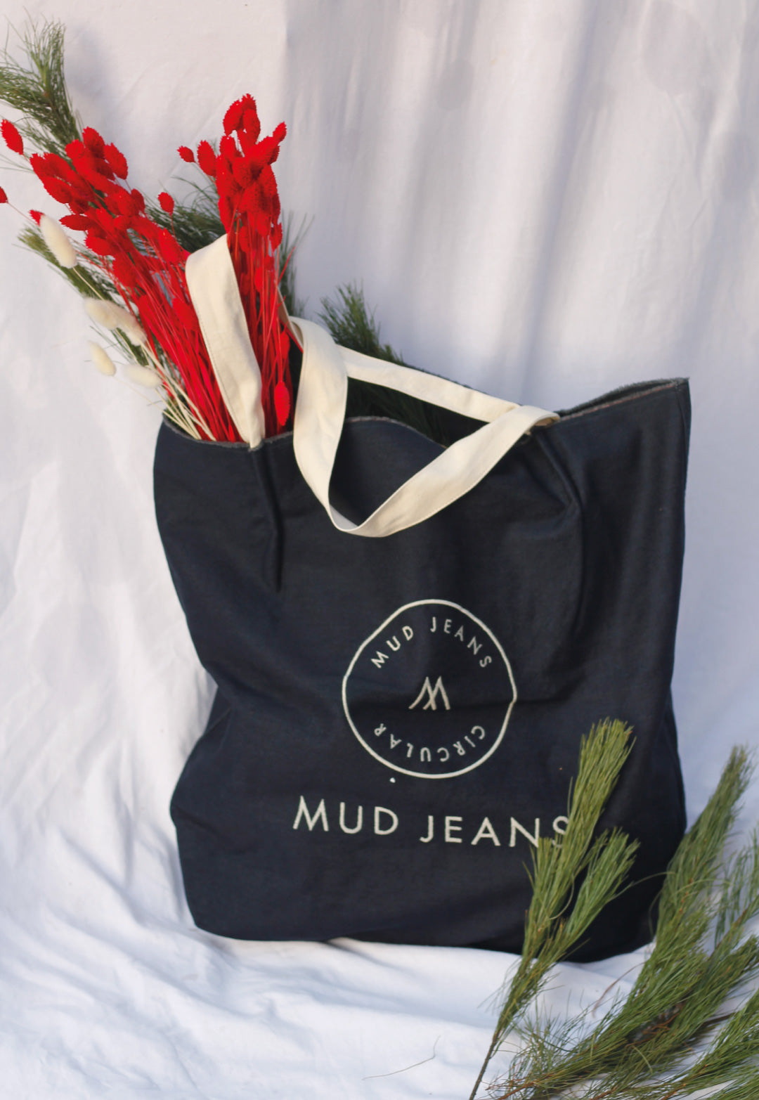 Sustainable MUD Jeans in dark wash denim featuring a button-up design, highlighting ethical fashion and style.