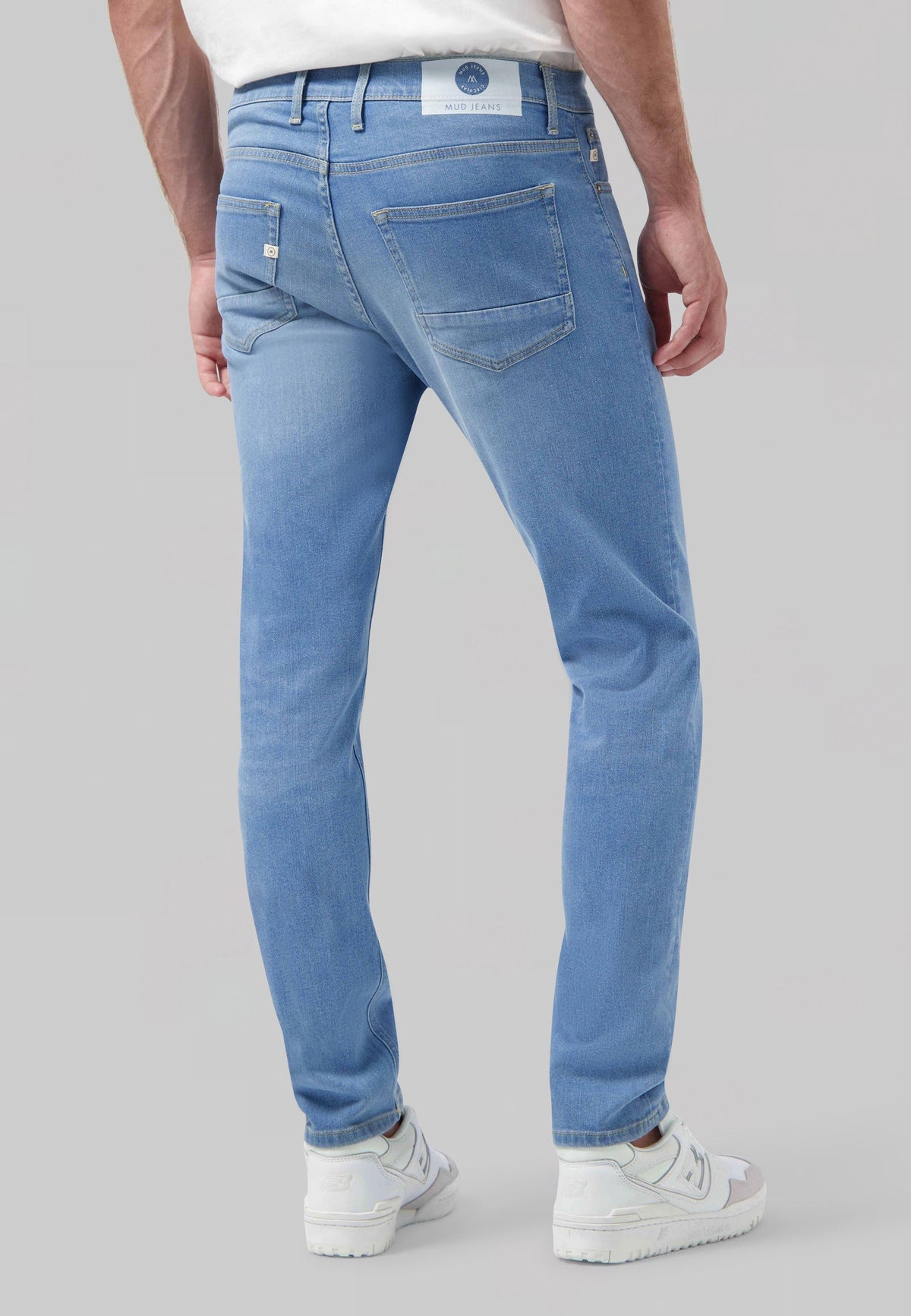 Sustainable MUD Jeans made from recycled denim in a dark wash, styled with a black t-shirt, showcasing ethical fashion.