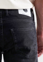 Sustainable MUD Jeans in deep blue denim, crafted ethically, showcasing a classic fit, paired with casual sneakers.