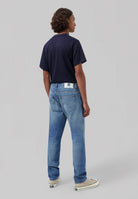 Sustainable MUD Jeans in dark blue denim, ethically made, showcasing a regular fit with rolled cuffs.