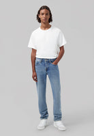 Sustainable MUD Jeans made from organic cotton, classic fit in faded blue denim, paired with white sneakers.