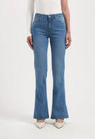 High-waisted, light blue flared jeans paired with a long-sleeve white top, showcasing a stylish casual outfit.