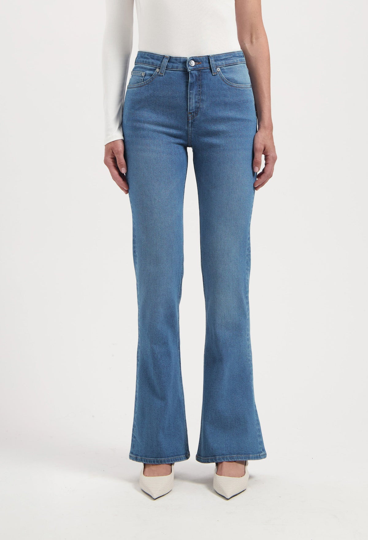 High-waisted, light blue flared jeans paired with a long-sleeve white top, showcasing a stylish casual outfit.