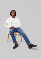 Sustainable MUD Jeans in blue denim, featuring classic fit, paired with white shirt, embodying ethical fashion.