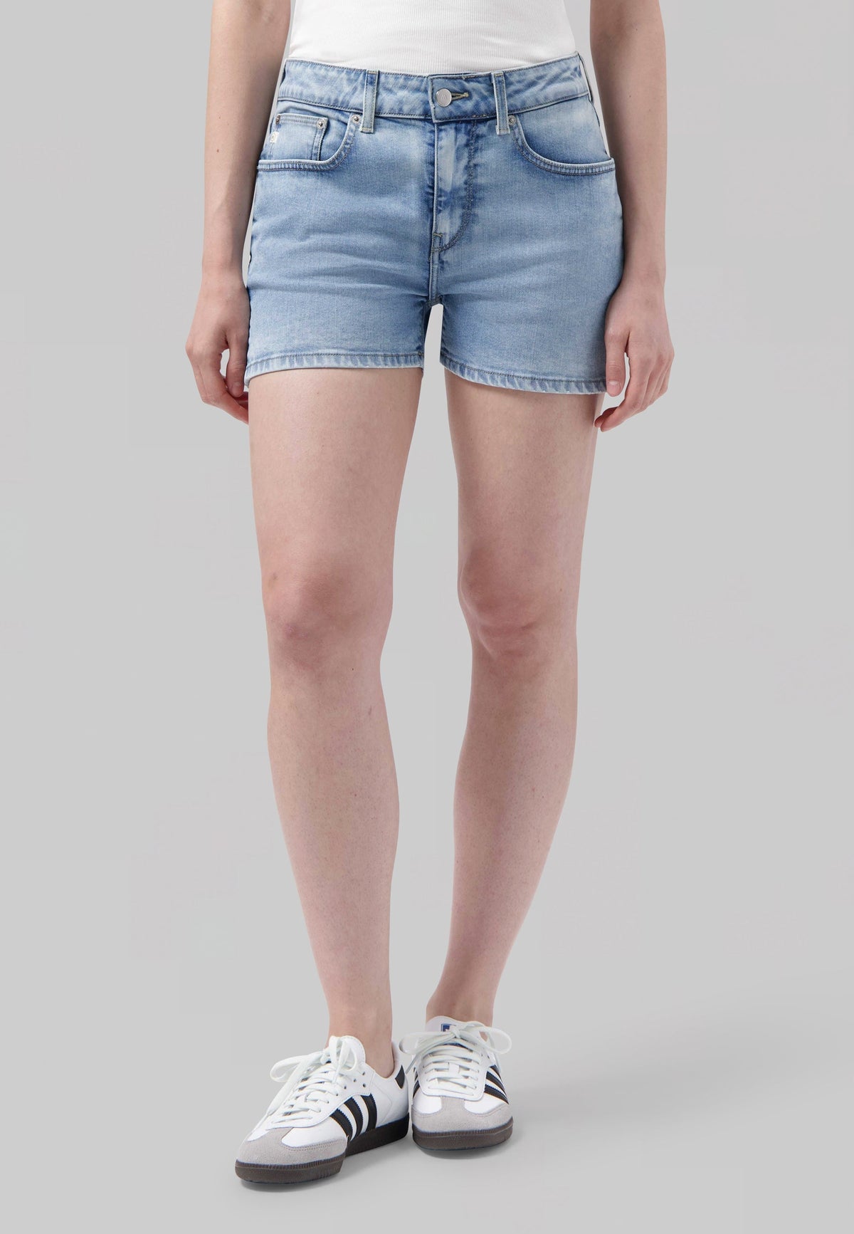Light blue denim shorts with five-pocket design and casual fit, paired with white and black sneakers, perfect for summer.