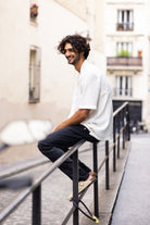 Sustainable MUD Jeans in dark denim, ethically crafted, paired with a black t-shirt, showcasing eco-friendly fashion.