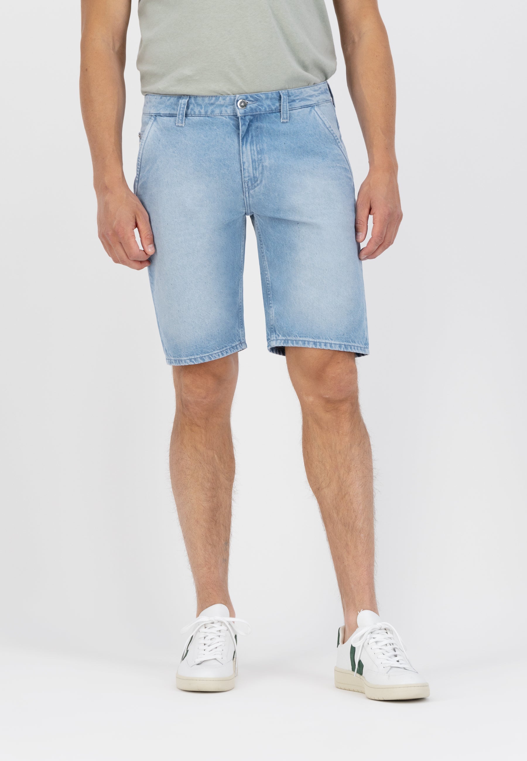 Sustainable MUD Jeans in light blue denim, featuring a classic straight fit, paired with a black sweater for an ethical look.