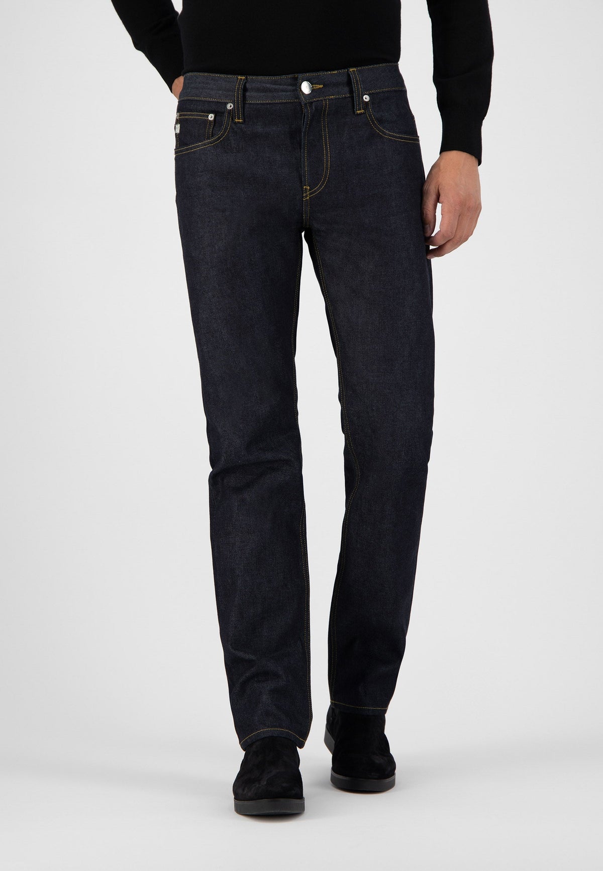 Sustainable MUD Jeans made from organic cotton, showcasing dark blue denim in a classic fit, paired with a black turtleneck.