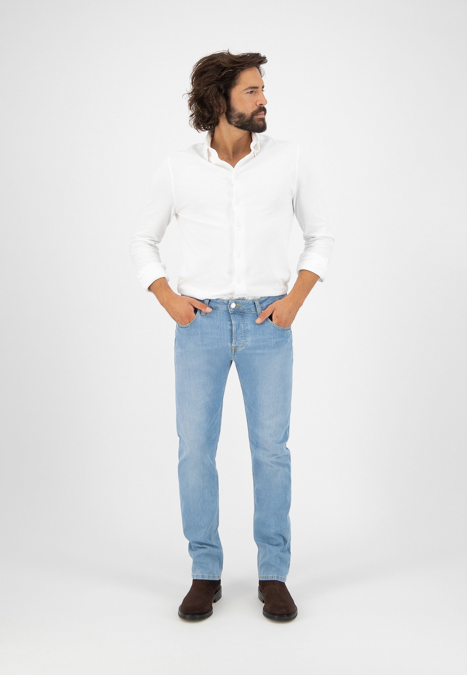 Sustainable MUD Jeans in dark blue denim with cargo pockets, crafted ethically, paired with casual white sneakers.