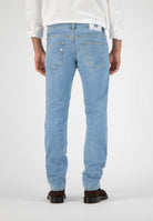 Sustainable MUD Jeans crafted from organic cotton, featuring dark blue denim in a relaxed fit, paired with black boots.