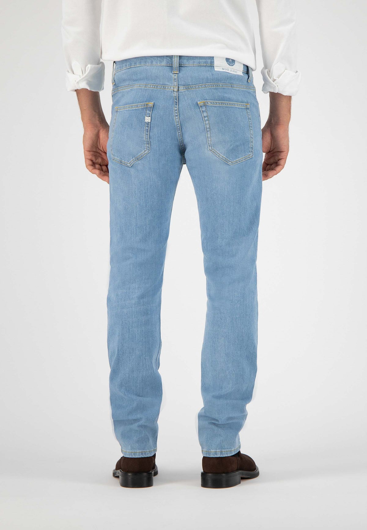 Sustainable MUD Jeans crafted from organic cotton, featuring dark blue denim in a relaxed fit, paired with black boots.