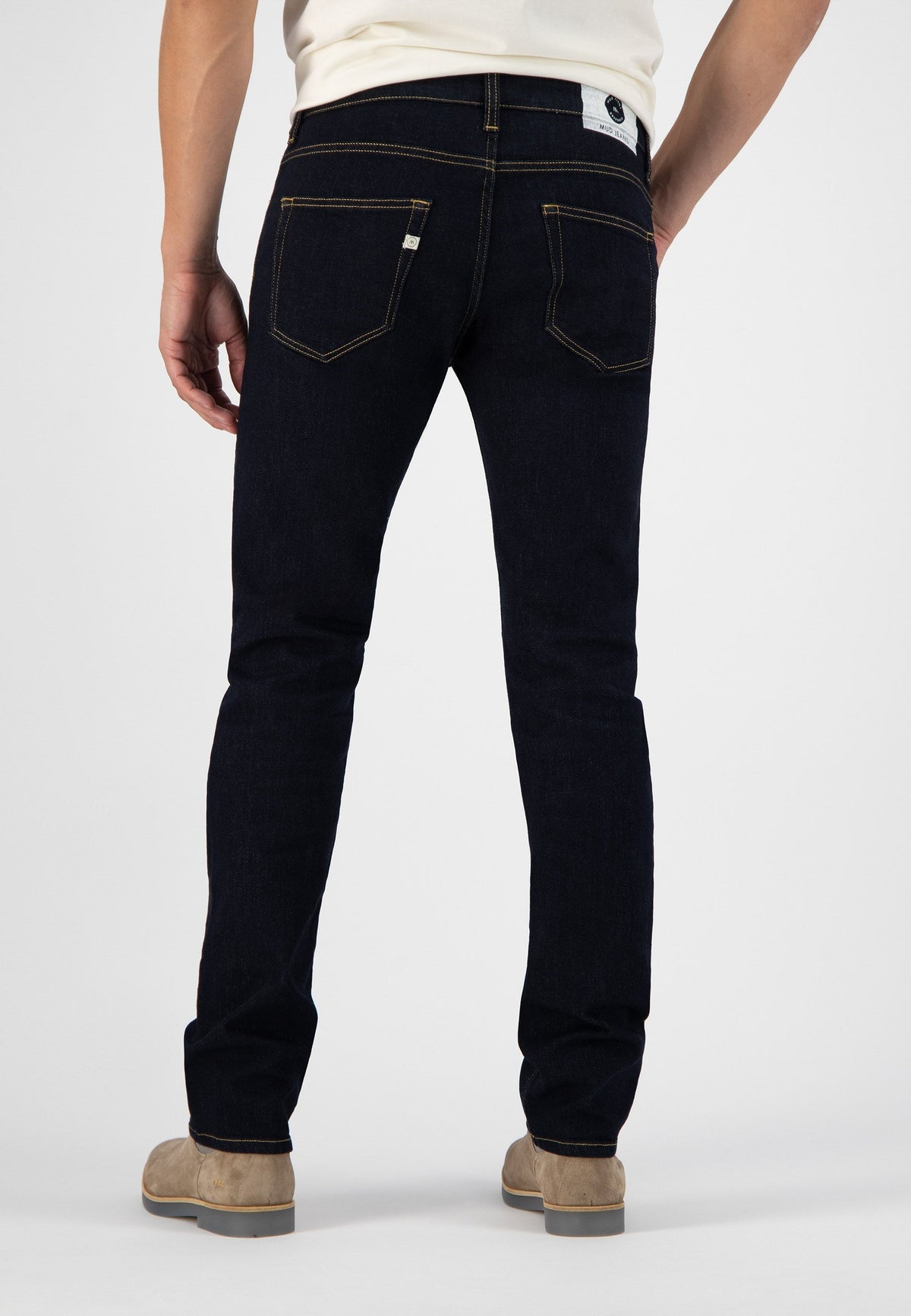 Sustainable MUD Jeans in light blue, crafted ethically from organic cotton, worn with a simple black t-shirt.