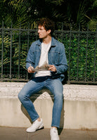 Sustainable MUD Jeans made from organic cotton, featuring dark blue denim in a relaxed fit with black leather boots.