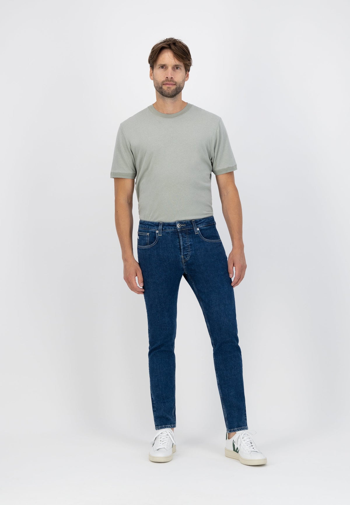 Sustainable MUD Jeans in light blue denim, paired with a gray sweater, emphasizing ethical and eco-friendly fashion.
