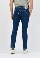 Sustainable MUD Jeans crafted from organic cotton, light blue denim with a classic fit, worn with a black sweater.