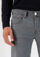 Sustainable Mud Jeans in deep blue denim crafted ethically, featuring a slim fit, paired with beige suede sandals.