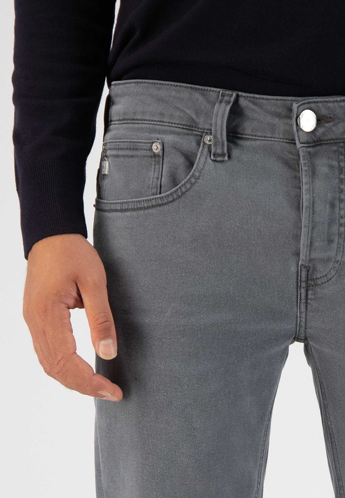 Sustainable Mud Jeans in deep blue denim crafted ethically, featuring a slim fit, paired with beige suede sandals.