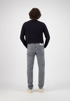 Sustainable MUD Jeans in dark blue denim, showcasing ethical craftsmanship and a sleek, tapered fit with classic stitching.
