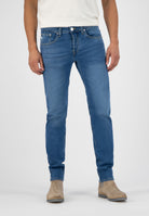 Sustainable MUD Jeans in dark indigo denim with a side pocket detail, demonstrating ethical fashion practices.