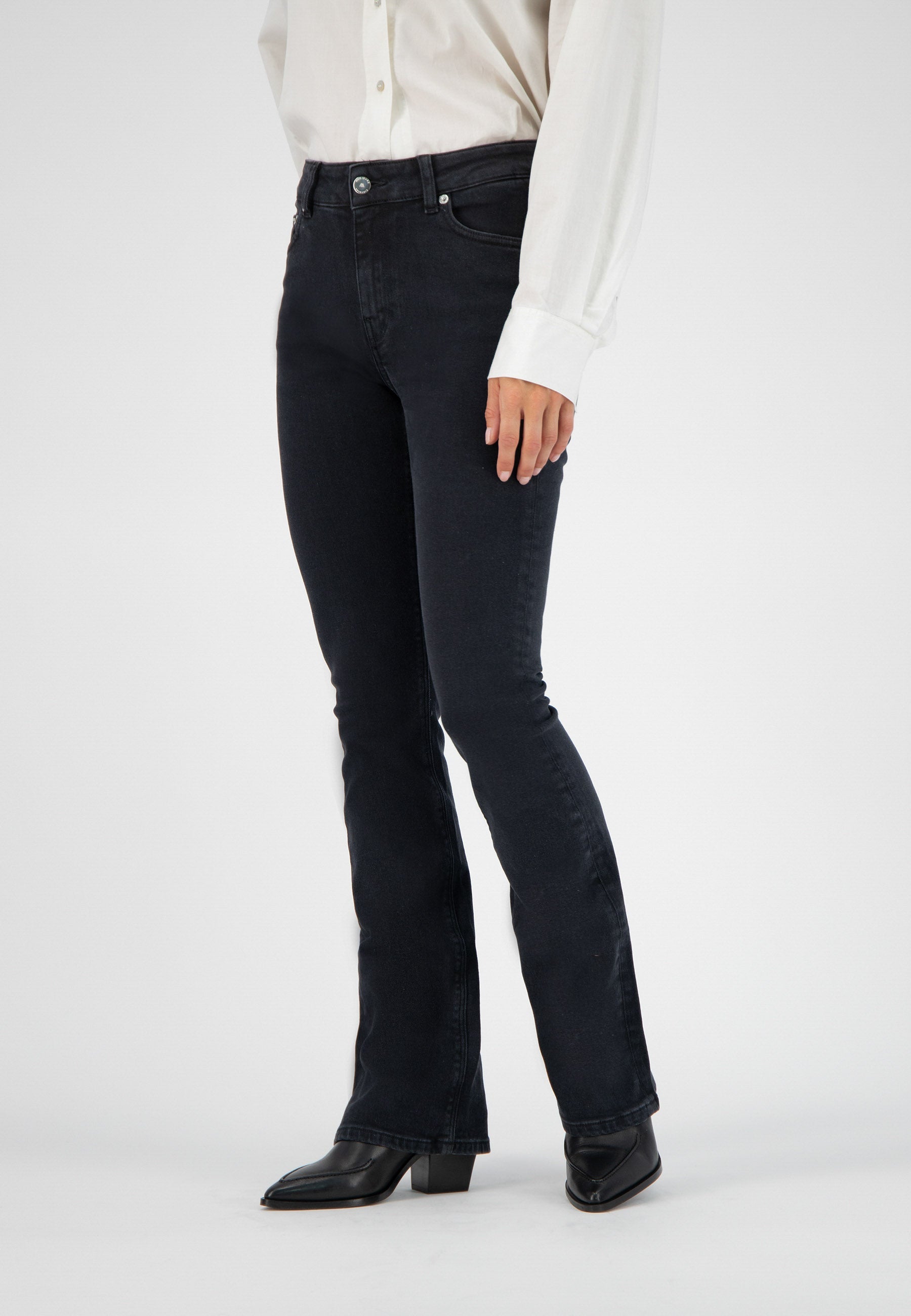 Black flared denim jeans paired with a classic white button-up shirt and black leather ankle boots.