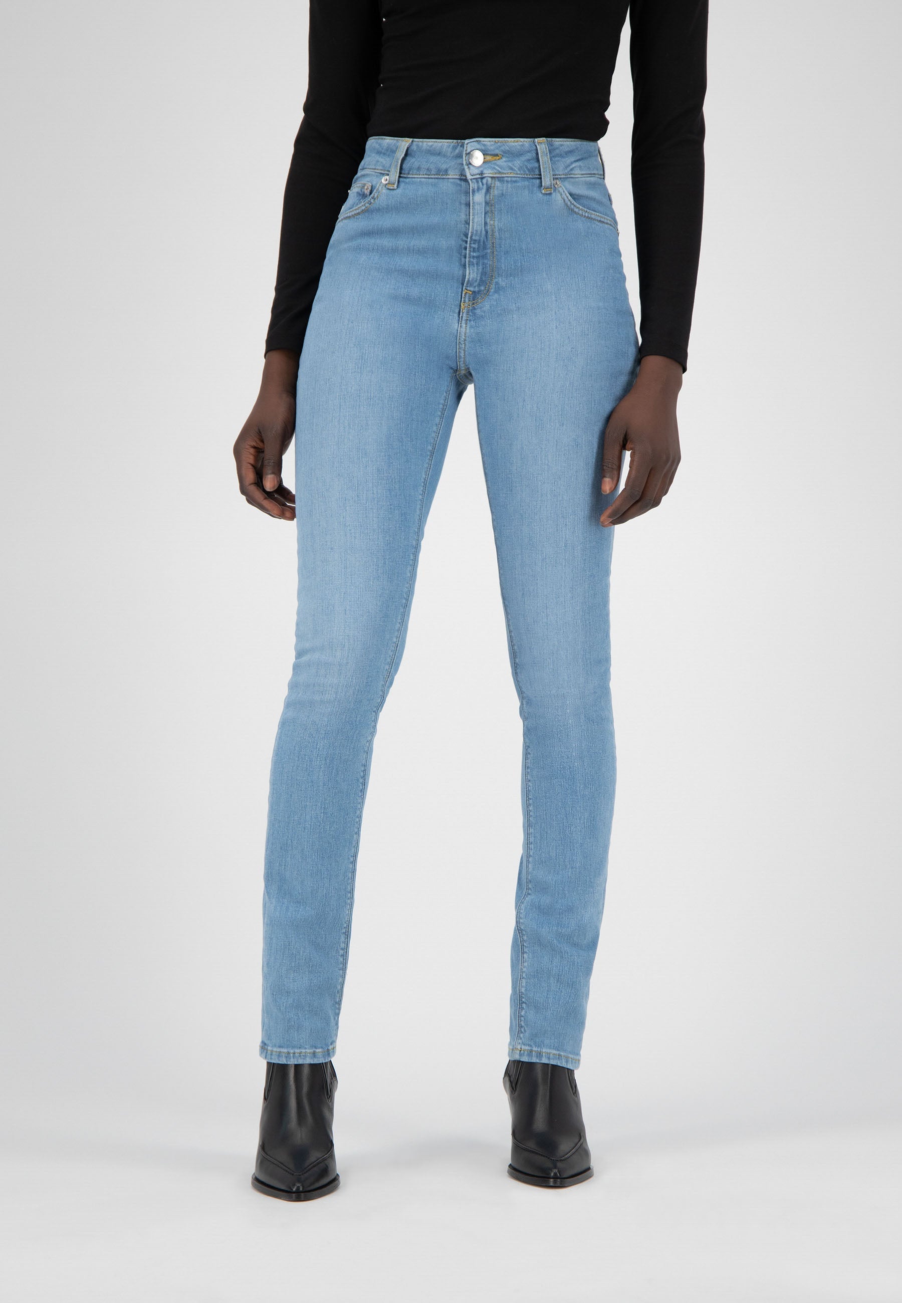 Light blue slim-fit jeans paired with a black long-sleeve top, showcasing classic five-pocket design and high-waisted style.