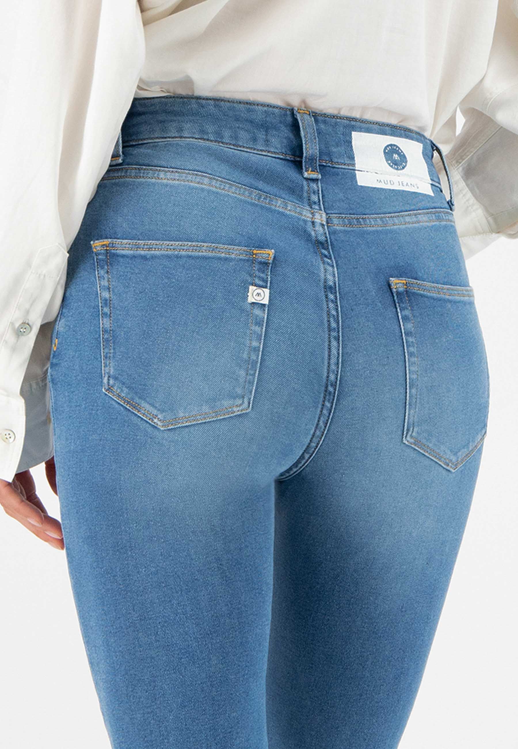 Close-up of light blue eco-friendly jeans from MUD Jeans, showcasing back pockets and sustainable design.