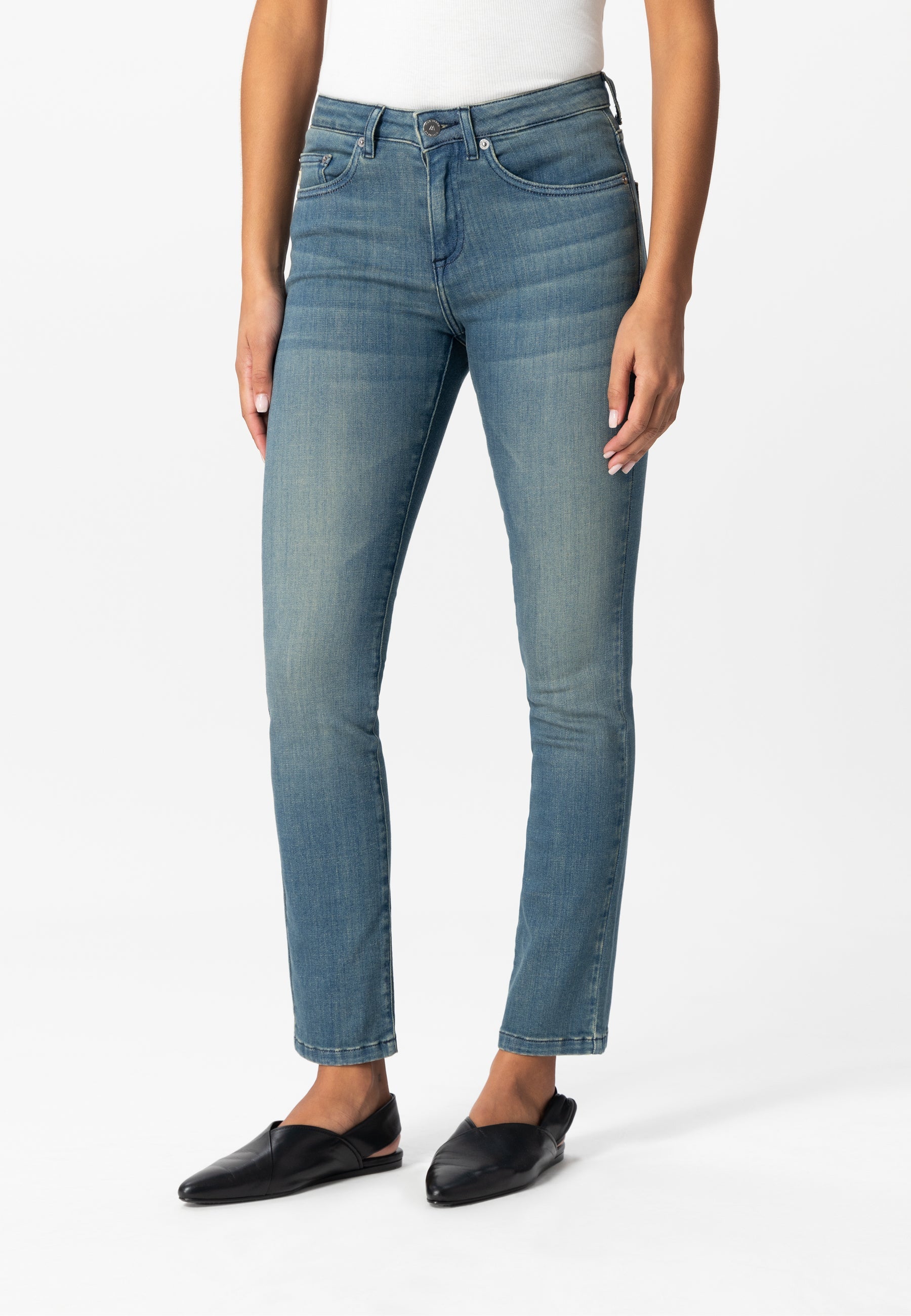 Straight-leg blue denim jeans styled with black flats and a white top, showcasing a classic casual look.
