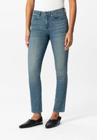 Straight-leg blue denim jeans styled with black flats and a white top, showcasing a classic casual look.