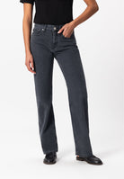 Casual black high-waisted jeans styled with a fitted black top and classic black loafers, showcasing a relaxed fit design.